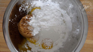 Combining the egg yolks, sweetener and arrowroot powder in a mixing bowl.