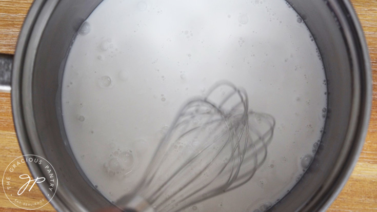 Heating the coconut milk in a pot.