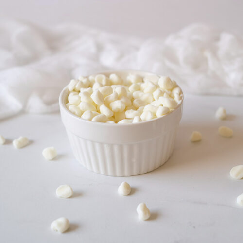 A white bowl filled with Dip N' Dots Ice Cream. A few white dots lay scattered around the base of the bowl.