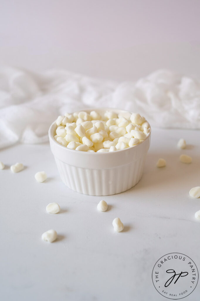 A white bowl filled with Dip N' Dots Ice Cream. A few white dots lay scattered around the base of the bowl.