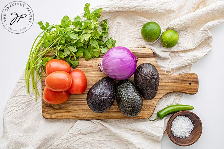 Guacamole Recipe ingredients collected on a cutting board.