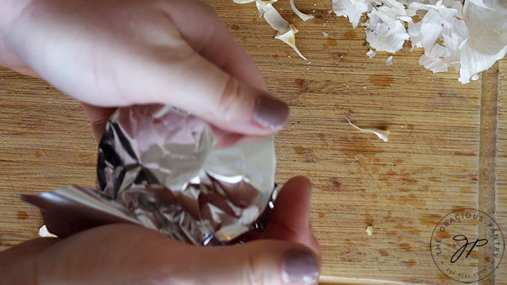 Wrapping the garlic and tart pan with foil for roasting.