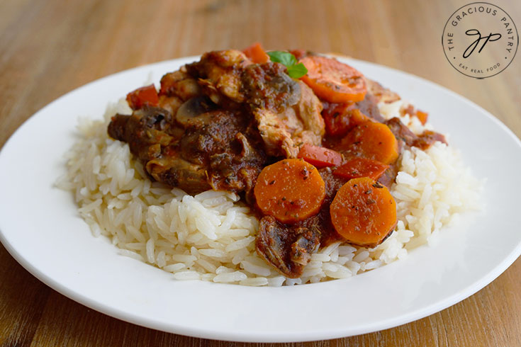 The finished Slow Cooker Chicken Cacciatore served over rice on a white plate.