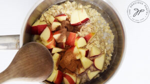 Combining all the ingredients for this Apple Pie Oatmeal Recipe in a small pot to cook.
