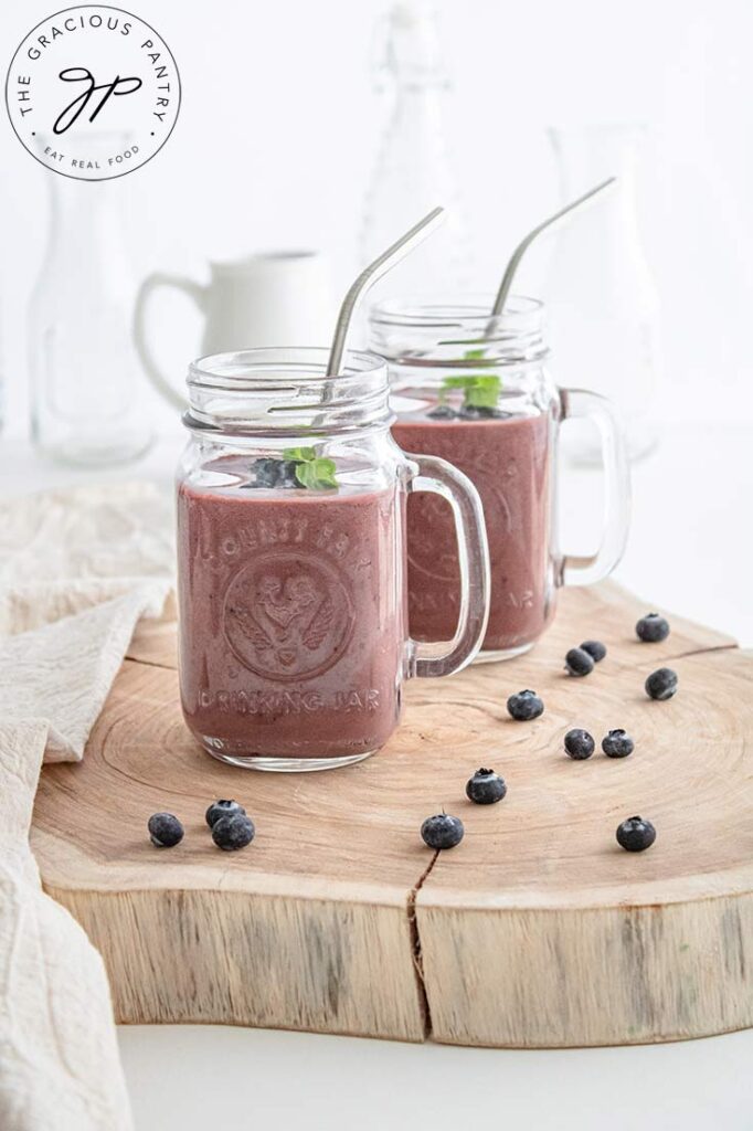 A side view of two glass canning jar mugs filled with this Acai Smoothie.