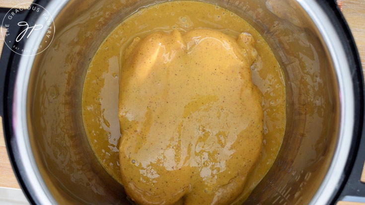 Carolina mustard barbecue sauce poured over frozen chicken in an instant pot.