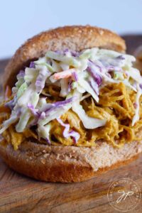 A single Carolina Gold BBQ Chicken Sandwich piled high with shredded chicken and cole slaw.
