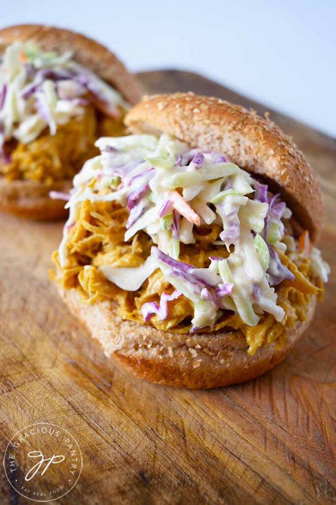 Two Carolina Gold BBQ Chicken Sandwiches with the top bun sitting off to the sides of the sandwiches.