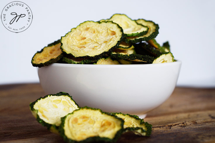 The finished Dehydrated Zucchini Chips in a small, white serving bowl.