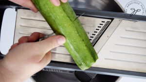 Cutting the zucchini in half for easier handling.