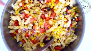 Mixing all the Mexican Pasta Salad ingredients into the pasta.