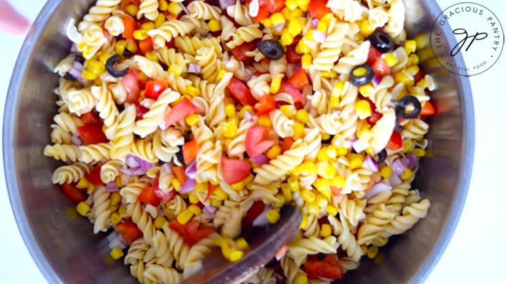 Mixing all the Mexican Pasta Salad ingredients into the pasta.