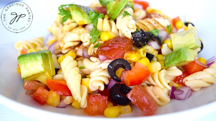 Sprinkling chopped cilantro over the finished Mexican Pasta Salad.