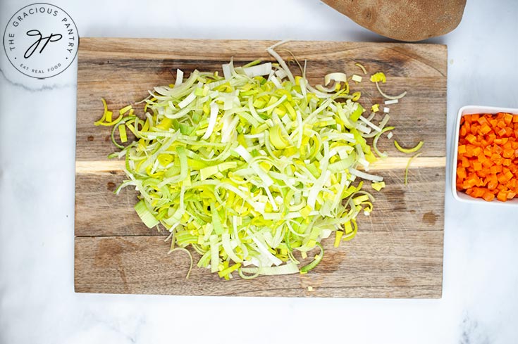 The finely cut leeks in a pile on a cutting board.