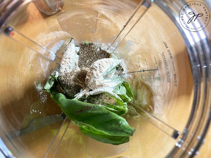 All the ingredients for this Lemon Basil Dressing Recipe sitting in a blender cup, waiting to be blended into dressing.