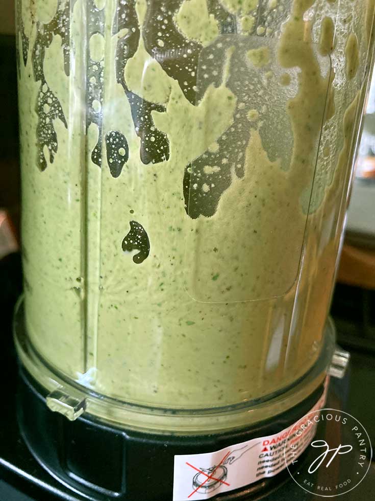 The Lemon Basil Dressing Recipe being blended in a blender.