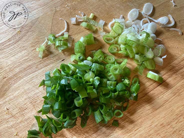 Sliced green onions on a cutting board.