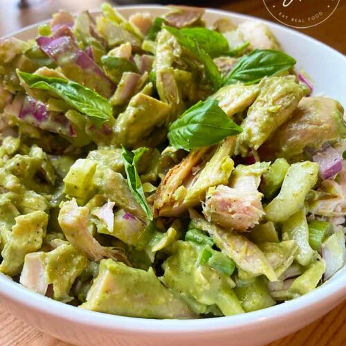 An overhead view of a white bowl filled with this lemon chicken salad recipe.