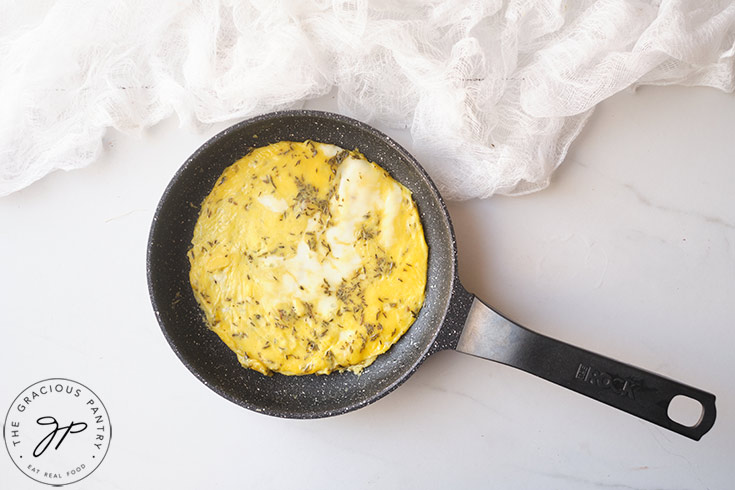 The egg mixture cooking in a skillet.