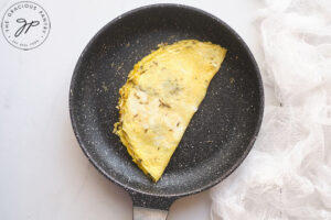 The cooked egg in the pan, folded in half to form the omelet.
