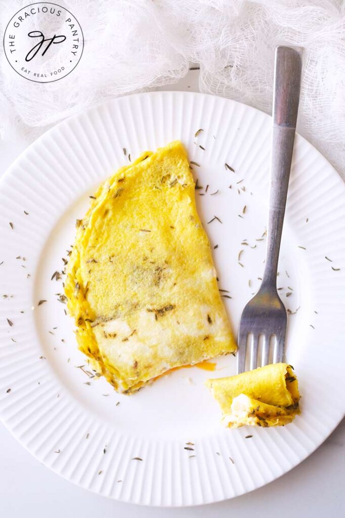 A single bit of this One Egg Omelet sits on a fork, next to the omelet.