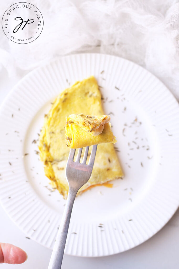 An overhead view of the first bite of One Egg Omelet being lifted towards the camera.