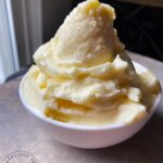 A white bowl filled with Pineapple Whip, piled high in the bowl.