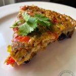 A single slice of this Southwestern Crustless Quiche on a white plate.