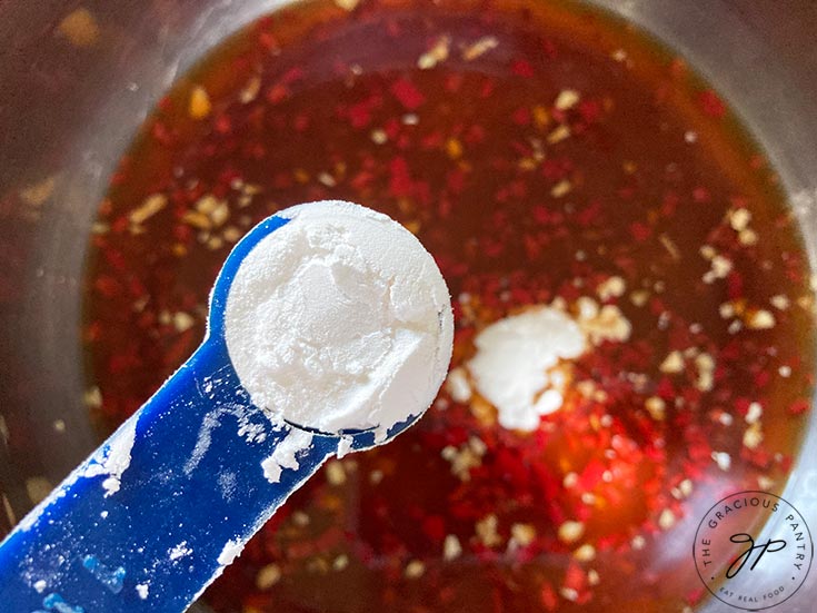 Adding arrowroot powder to the pot.