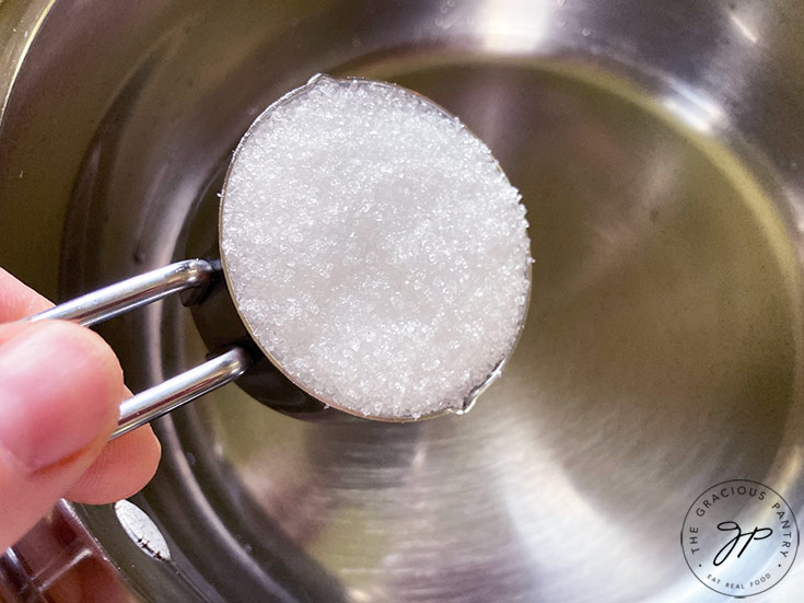 Pouring sweetener into pot.