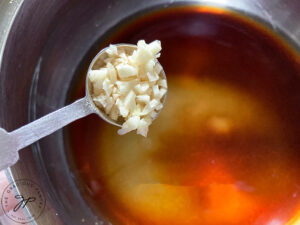 Adding garlic to the pot.