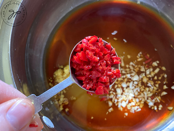 Adding peppers to the pot.