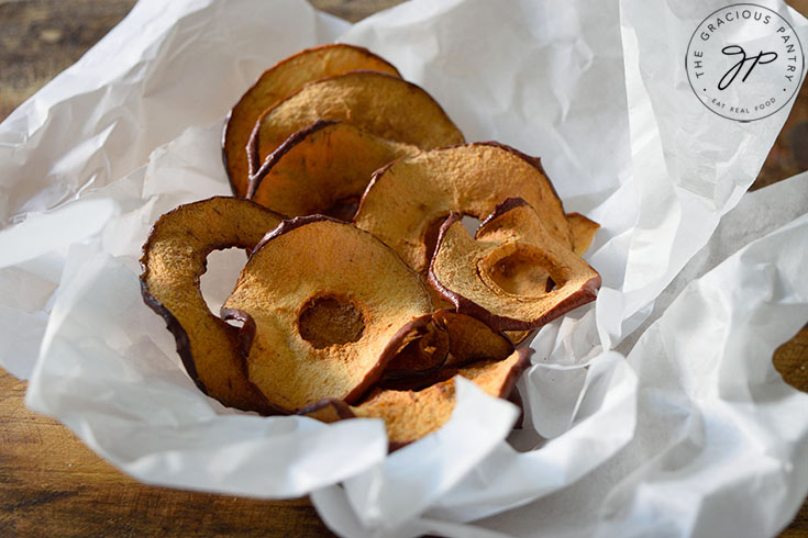 The finished Air Fryer Apple Chips in some crinkled parchment.