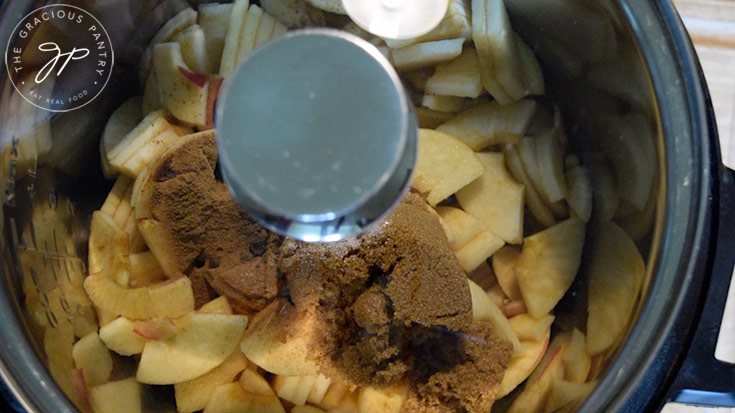 Placing the lid on the pot to cook the Amish Apple Butter Recipe.