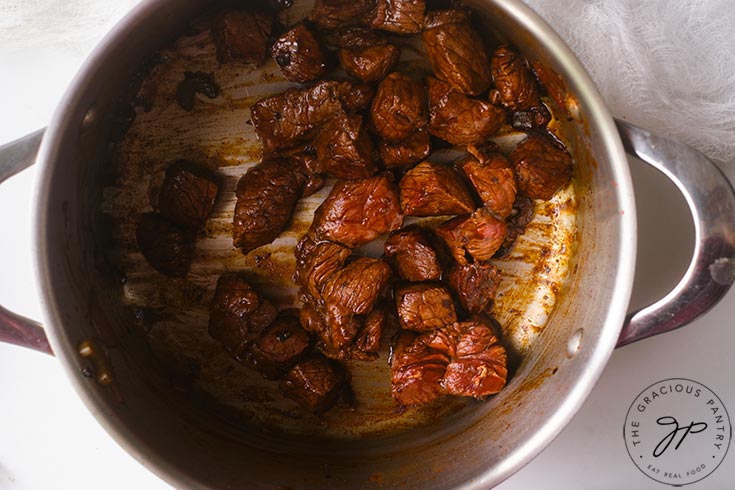 Browning the bison in a pot.