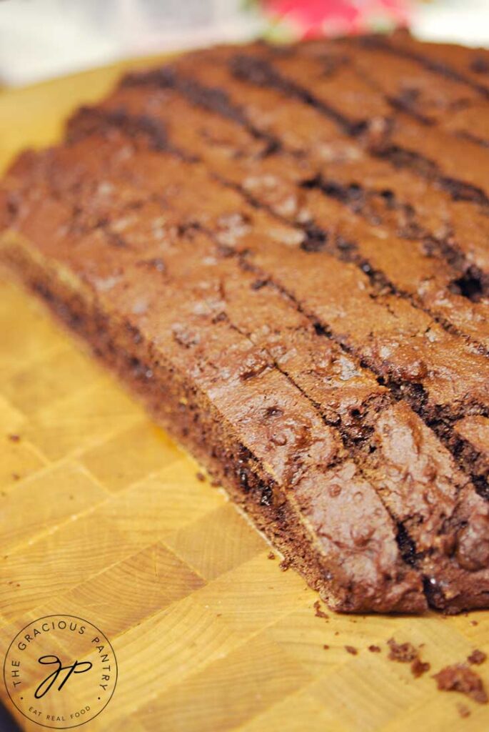 Cutting the biscotti loaf into slices on a wooden cutting board.