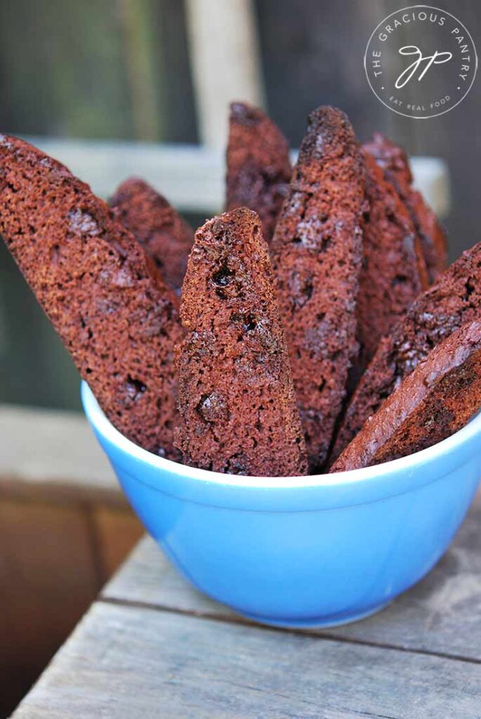 An overhead view looking down at an angle at a bowl of chocolate biscotti standing on end in.