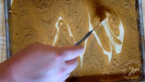 Swirling the cinnamon into the batter with a knife.