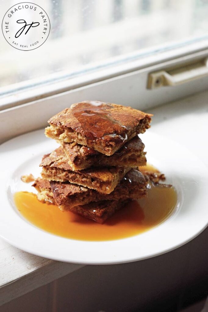 Cinnamon Swirl Pancakes served on a white plate, sitting on a white windowsill.