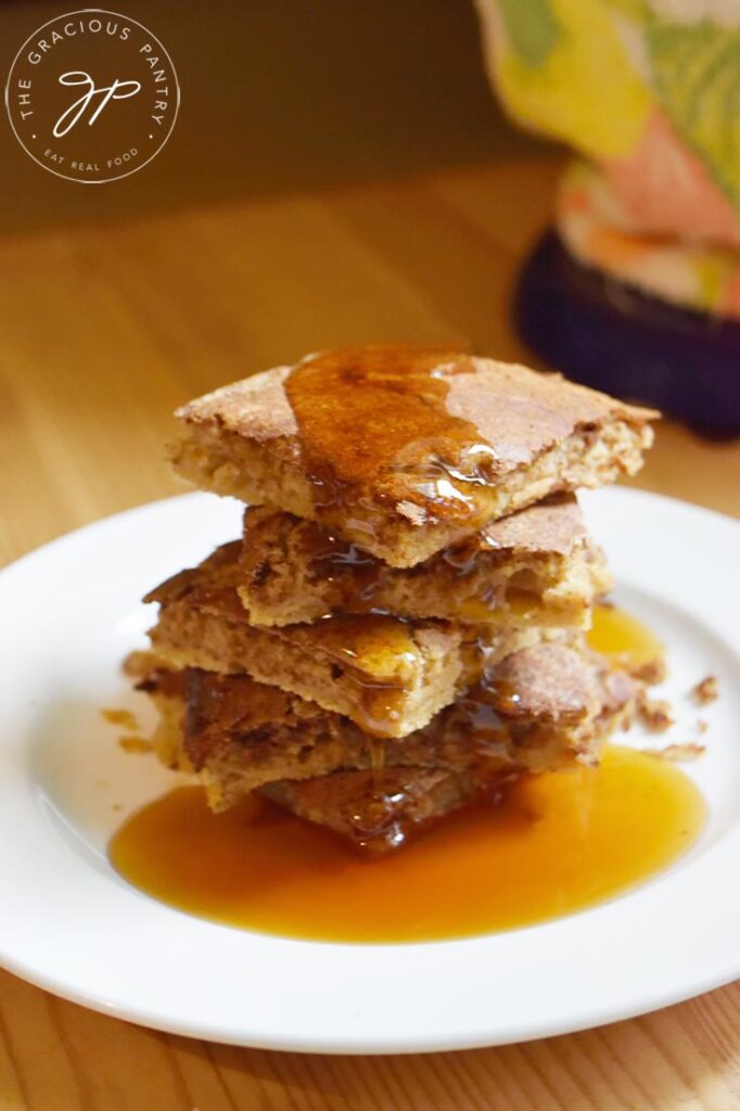 Cinnamon Swirl Pancakes on a white plate sitting on a wooden table.