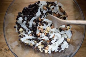 The ingredients for this Low Carb Trail Mix Recipe, sitting in a clear mixing bowl, waiting to be mixed together.