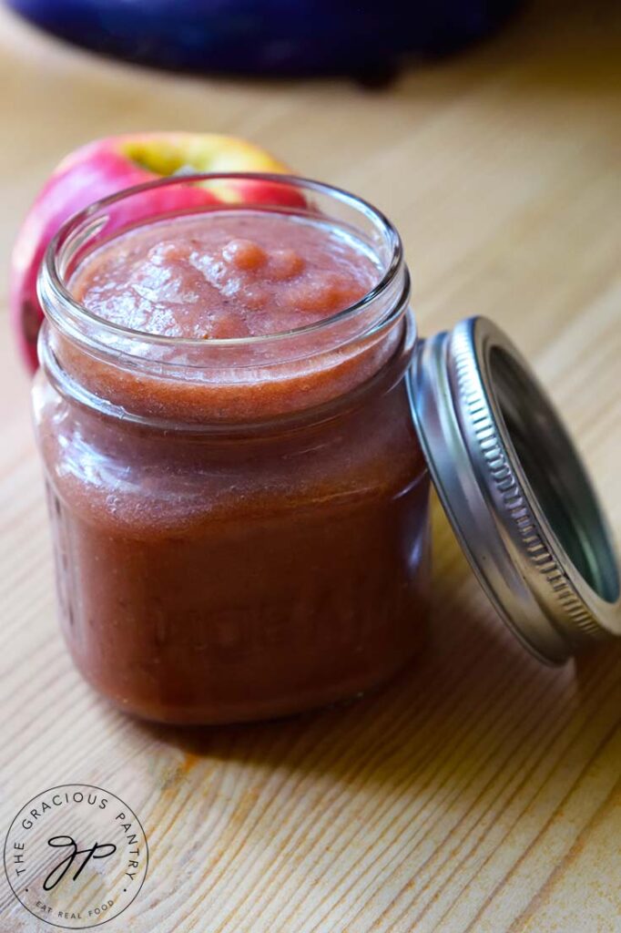 A side view of a canning jar filled with Strawberry Apple Sauce.