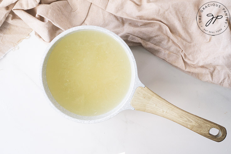 Honey dissolving in a pot of water.