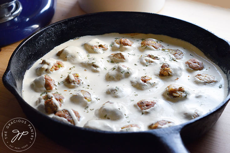 The finished Swedish Meatballs in a cast iron skillet with sauce poured over the top.