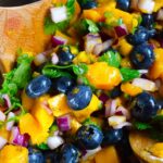 An up close shot of this Blueberry Mango Salsa in a mixing bowl.
