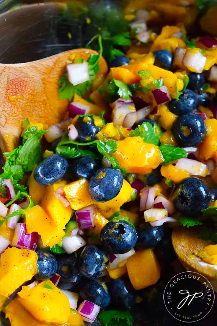 An up close shot of this Blueberry Mango Salsa in a mixing bowl.