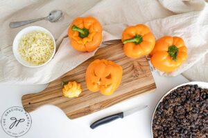 Cutting the Jack-O-Lantern faces into the peppers.