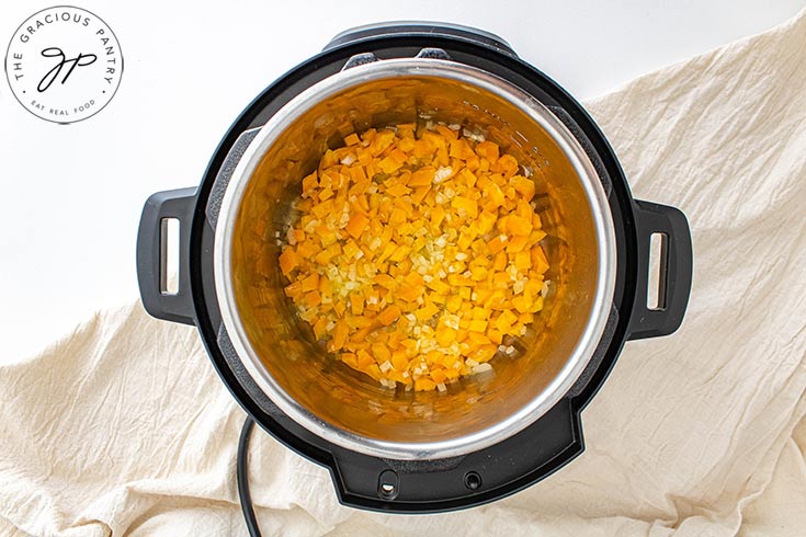 The onions and diced pepper sautéing in an Instant Pot.