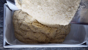 Pouring the batter into the lined and oiled loaf pan.