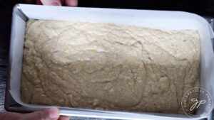 Gently shaking the loaf pan to settle the batter.